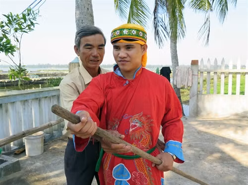 Ông Đỗ Mỹ Tân hướng dẫn thanh niên trẻ tập hát bả trạo.