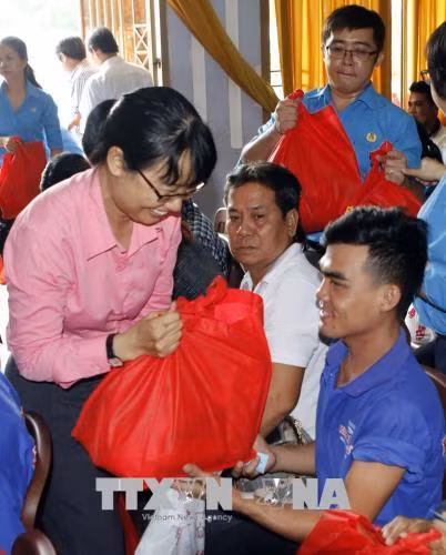 Bà Trần Thị Diệu Thúy, Chủ tịch Liên đoàn Lao độngThành phố tặng quà công nhân lao động các dân tộc thiểu số. Ảnh: Hoàng Hải -TTXVN.