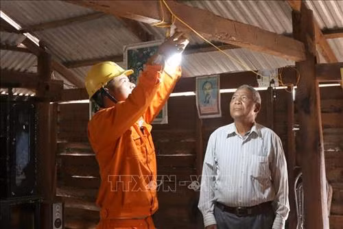 Lắp đèn điện cho các hộ dân làng Hek, xã Chư A Thai, huyện Phú Thiện, tỉnh Gia Lai. Ảnh: Dư Toán - TTXVN