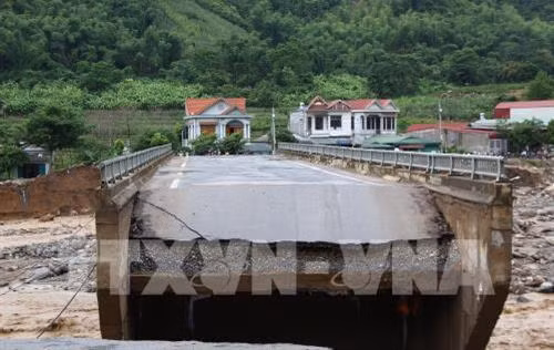 Cầu Nặm Păm, thị trấn Ít Ong, huyện Mường La bị lũ cuốn trôi hai đầu cầu, giao thông bị chia cắt. Ảnh: Nguyễn Cường - TTXVN.