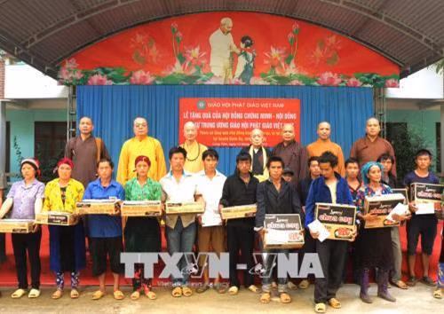 Lãnh đạo Giáo hội Phật giáo Việt Nam trao quà cho người dân xã Lùng Tám, bị thiệt hại nặng nề do mưa lũ gây ra. Ảnh: Minh Tâm - TTXVN