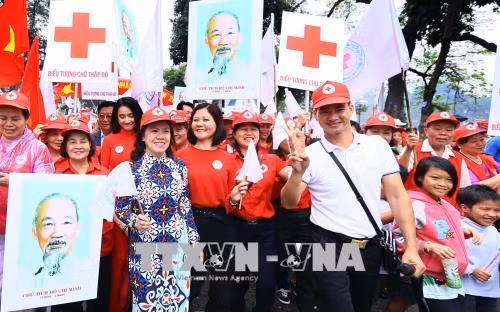 Các đại biểu tham gia đi bộ hưởng ứng chương trình “Chung sức vì nhân đạo”, phát động “Tháng nhân đạo” năm 2018, kỷ niệm Ngày chữ Thập đỏ -Trăng lưỡi liềm đỏ Quốc tế (8/5). Ảnh: Quang Quyết-TTXVN