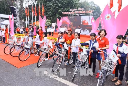 Ban Tổ chức tặng xe đạp cho các em học sinh của thành phố Hà Nội vượt khó vươn lên trong học tập. Ảnh: Quang Quyết-TTXVN