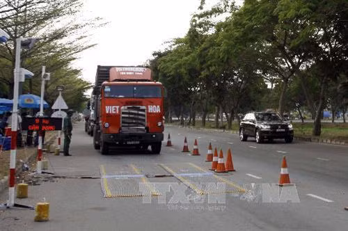 Kiểm tra phương tiện xe container chở hàng hóa tại trạm cân đường Nguyễn Văn Linh, quận 7 , Thành phố Hồ Chí Minh. Ảnh: Hoàng Hải-TTXVN