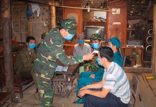 Cán bộ, chiến sỹ Đồn Biên phòng Tổng Cọt đo thân nhiệt cho người dân. Ảnh: Chu Hiệu - TTXVN