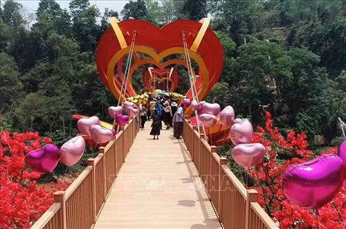 Du khách tham quan và trải nghiệm cầu kính tình yêu tại Khu du lịch sinh thái thác Dải Yếm, huyện Mộc Châu, tỉnh Sơn La. Ảnh: TTXVN