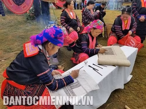 Đồng bào dân tộc Mông giới thiệu nghệ thuật vẽ sáp ong trên vải tại Làng Văn hóa. Ảnh: Nam Sương