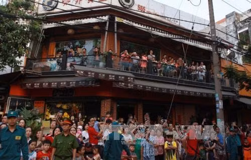 Đông đảo người dân hân hoan chào đón đoàn diễu hành qua các đường phố lớn của Quận 5. Ảnh: Phương Vy - TTXVN
