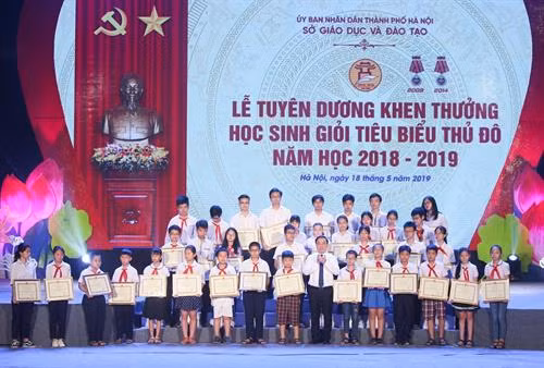 Giám đốc Sở Giáo dục và Đào tạo Hà Nội Chử Xuân Dũng tặng giấy khen cho các em học sinh tiêu biểu của các cấp học. Ảnh: Thanh Tùng- TTXVN