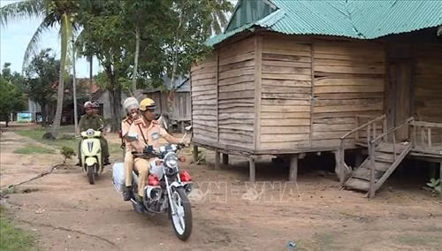 Công an huyện Kong Chro dùng loa di động, tuyên truyền đến từng hộ gia đình người dân tộc thiểu số về tác hại của việc uống rượu, bia khi tham gia giao thông. Ảnh: Hồng Điệp - TTXVN
