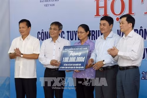 Bảo hiểm xã hội Việt Nam trao tặng tiền ủng hộ những người có hoàn cảnh khó khăn mua thẻ bảo hiểm y tế. Ảnh: Phan Tuấn Anh - TTXVN