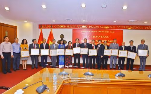 Đại diện Đảng ủy Khối các Cơ quan Trung ương trao Kỷ niệm chương “Vì sự nghiệp xây dựng Đảng ủy Khối các Cơ quan Trung ương" cho 17 đảng viên thuộc Đảng ủy TTXVN. Ảnh: Minh Quyết – TTXVN