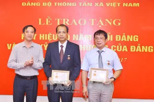 Đồng chí Nguyễn Thành Nam, Ủy viên Ban Thường vụ, Chủ nhiệm Ủy ban Kiểm tra Đảng ủy Khối các Cơ quan Trung ương trao Kỷ niệm chương “Vì sự nghiệp Kiểm tra của Đảng” cho 2 đảng viên có nhiều thành tích trong công tác Kiểm tra Đảng của Đảng bộ TTXVN. Ảnh: Minh Quyết - TTXVN