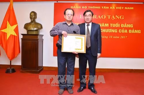Phó Bí thư Đảng ủy Khối các Cơ quan Trung ương Phạm Quang Thao trao Huy hiệu 70 năm tuổi Đảng truy tặng cố nhà báo Đỗ Phượng cho thân nhân Nhà báo. Ảnh: Minh Quyết - TTXVN