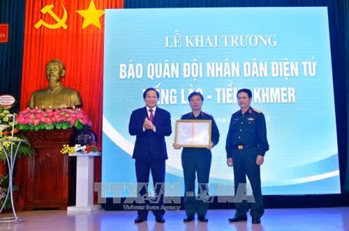 Bộ trưởng Bộ Thông tin và Truyền thông Trương Minh Tuấn trao giấy phép hoạt động báo điện tử cho Quân đội Nhân dân điện tử tiếng Lào và tiếng Khmer. Ảnh: Minh Quyết - TTXVN