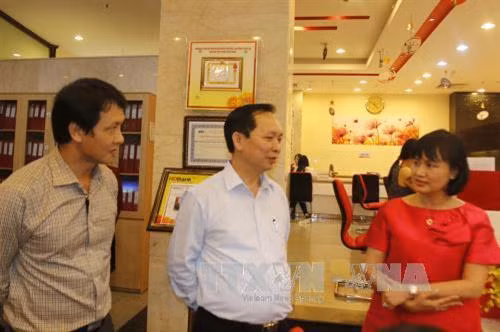 Phó Thống đốc Ngân hàng Nhà nước Đào Minh Tú gặp gỡ khách hàng đến giao dịch tại Ngân hàng HDBank chi nhánh Thành phố Hồ Chí Minh Ảnh: Hoàng Hải-TTXVN