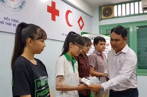 Hội Chữ thập đỏ thành phố Hồ Chí Minh trao các suất hỗ trợ học tập cho các học sinh trường Lê Hồng Phong. Ảnh: Thế Anh - TTXVN