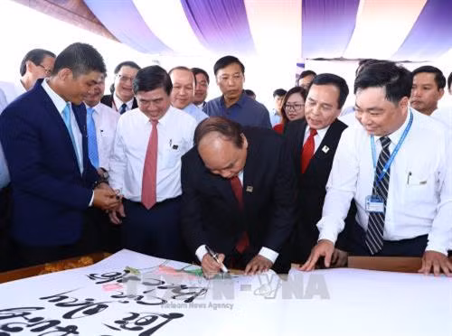 Thủ tướng Nguyễn Xuân Phúc ký lưu niệm vào cuốn sách "Những lời dạy của Bác Hồ" viết bằng chữ thư pháp Việt lớn nhất tại Trường Đại học Nguyễn Tất Thành. Ảnh: Thống Nhất–TTXVN