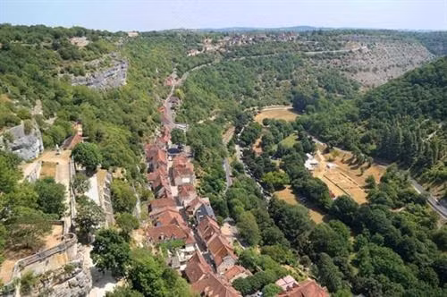 Ngôi làng cổ Rocamadour được xây dựng trên vách núi ở vùng Occitanie, miền tây nam Pháp. Từ thời Trung cổ, ngôi làng đã thu hút những người hành hương từ khắp châu Âu tới đây tham quan các công trình lịch sử và nhà thờ Đức Mẹ Maria. Thánh St Amator đã sống và qua đời tại ngôi làng Rocamadour ngay sau khi ông rời khỏi Jerusalem. Truyền thuyết kể rằng sau khi thi thể thánh St Amator được phát hiện, một số phép màu đã xảy ra. Ngôi làng bắt đầu thu hút nhiều người hành hương và ủng hộ từ các nhà vua Pháp, giúp ngôi làng xây dựng các nơi thờ cúng. Một lý do khác khiến Rocamadour thu hút nhiều du khách là phong cảnh đẹp. Các công trình cổ được xây dựng trên vách núi nhìn xuống sông Alzou. Các tòa nhà trong làng có độ cao cách mặt đất phía dưới khoảng 120m. Trung tâm của ngôi làng là nhà thờ hành hương Notre Dame, được cải tạo lại từ công trình gốc được xây dựng từ năm 1479. Ngoài ra, Rocamadour còn có nhiều công trình cổ kính khác được xây dựng từ thời Trung cổ. Du khách tham quan dọc một con đường dốc tại ngôi làng cổ Rocamadour. Những ngôi nhà được xây dựng trên vách đá dựng đứng.