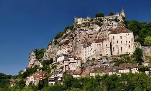 Ngôi làng cổ Rocamadour được xây dựng trên vách núi ở vùng Occitanie, miền tây nam Pháp. Từ thời Trung cổ, ngôi làng đã thu hút những người hành hương từ khắp châu Âu tới đây tham quan các công trình lịch sử và nhà thờ Đức Mẹ Maria. Thánh St Amator đã sống và qua đời tại ngôi làng Rocamadour ngay sau khi ông rời khỏi Jerusalem. Truyền thuyết kể rằng sau khi thi thể thánh St Amator được phát hiện, một số phép màu đã xảy ra. Ngôi làng bắt đầu thu hút nhiều người hành hương và ủng hộ từ các nhà vua Pháp, giúp ngôi làng xây dựng các nơi thờ cúng. Một lý do khác khiến Rocamadour thu hút nhiều du khách là phong cảnh đẹp. Các công trình cổ được xây dựng trên vách núi nhìn xuống sông Alzou. Các tòa nhà trong làng có độ cao cách mặt đất phía dưới khoảng 120m. Trung tâm của ngôi làng là nhà thờ hành hương Notre Dame, được cải tạo lại từ công trình gốc được xây dựng từ năm 1479. Ngoài ra, Rocamadour còn có nhiều công trình cổ kính khác được xây dựng từ thời Trung cổ. Du khách tham quan dọc một con đường dốc tại ngôi làng cổ Rocamadour. Những ngôi nhà được xây dựng trên vách đá dựng đứng.