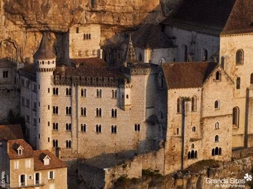 Ngôi làng cổ Rocamadour được xây dựng trên vách núi ở vùng Occitanie, miền tây nam Pháp. Từ thời Trung cổ, ngôi làng đã thu hút những người hành hương từ khắp châu Âu tới đây tham quan các công trình lịch sử và nhà thờ Đức Mẹ Maria. Thánh St Amator đã sống và qua đời tại ngôi làng Rocamadour ngay sau khi ông rời khỏi Jerusalem. Truyền thuyết kể rằng sau khi thi thể thánh St Amator được phát hiện, một số phép màu đã xảy ra. Ngôi làng bắt đầu thu hút nhiều người hành hương và ủng hộ từ các nhà vua Pháp, giúp ngôi làng xây dựng các nơi thờ cúng. Một lý do khác khiến Rocamadour thu hút nhiều du khách là phong cảnh đẹp. Các công trình cổ được xây dựng trên vách núi nhìn xuống sông Alzou. Các tòa nhà trong làng có độ cao cách mặt đất phía dưới khoảng 120m. Trung tâm của ngôi làng là nhà thờ hành hương Notre Dame, được cải tạo lại từ công trình gốc được xây dựng từ năm 1479. Ngoài ra, Rocamadour còn có nhiều công trình cổ kính khác được xây dựng từ thời Trung cổ. Du khách tham quan dọc một con đường dốc tại ngôi làng cổ Rocamadour. Những ngôi nhà được xây dựng trên vách đá dựng đứng.