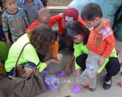 Đoàn từ thiện mang giày cho em nhỏ trường mầm non Huổi Mí. Ảnh: Văn Dũng - TTXVN