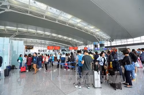 Hành khách làm thủ tục lên máy bay. Việc sử dụng thị thực điện tử sẽ rút ngắn thời gian làm thủ tục, tạo điều kiện thuận lợi cho du khách nước ngoài nhập cảnh, tìm đối tác kinh tế, tham quan du lịch ở Việt Nam. Ảnh: Huy Hùng – TTXVN
