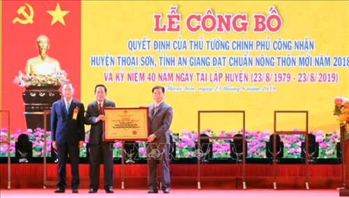 Thừa ủy quyền của Thủ tướng Chính phủ, ông Võ Anh Kiệt, Phó Bí thư, Chủ tịch HĐND tỉnh An Giang trao Bằng công nhận đạt chuẩn nông thôn mới cho Đảng bộ và nhân dân huyện Thoại Sơn. Ảnh: Công Mạo-TTXVN