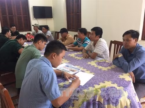 Lực lượng chức năng làm việc với các đối tượng khai thác cát trái phép. Ảnh: Thành Chung- TTXVN
