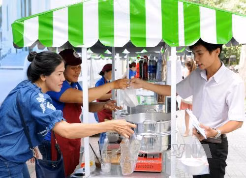 Khách tham quan, mua sắm tại phố ẩm thực hàng rong. Ảnh: An Hiếu - TTXVN