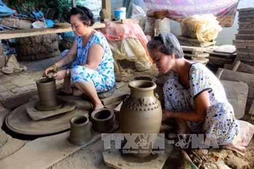 Sản xuất gốm tại làng gốm Mỹ Thiện. Ảnh: Phước Ngọc - TTXVN