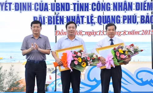 Phó Chủ tịch UBND tỉnh Quảng Bình Trần Tiến Dũng trao quyết định của UBND tỉnh Quảng Bình công nhận bãi biển Nhật lệ - Quang Phú – Bảo Ninh là điểm du lịch cấp tỉnh. Ảnh: Minh Đức- TTXVN