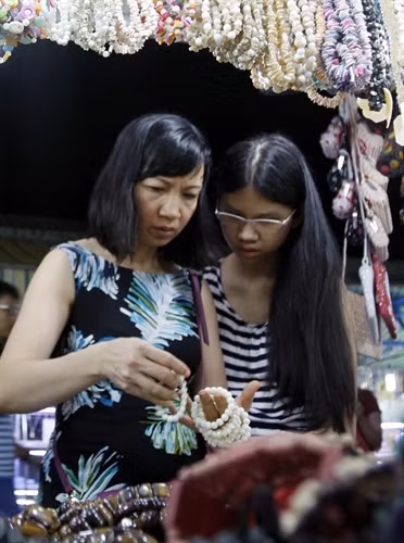 Du khách chọn mua đồ lưu niệm tại chợ đêm Dinh Cậu