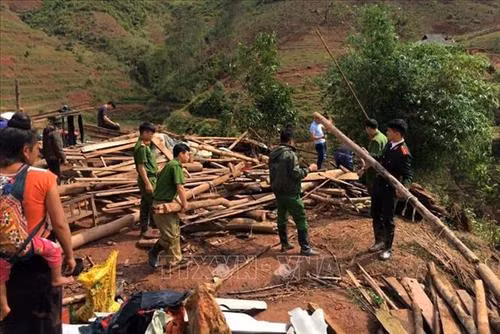 Lực lượng Công an huyện Tân Uyên giúp các hộ dân có nhà bị sập xã Nậm Sỏ khắc phục thiên tai. Ảnh: TTXVN phát