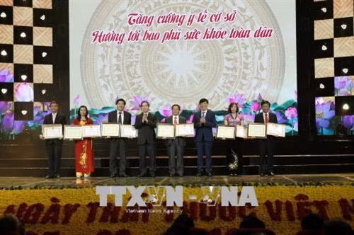 Đồng chí Nguyễn Văn Bình, Ủy viên Bộ Chính trị, Bí thư Trung ương Đảng, Trưởng Ban Kinh tế Trung ương và Thứ trưởng Bộ Y tế Nguyễn Thanh Long trao Bằng khen của Bộ Y tế cho các đơn vị có thành tích xuất sắc trong công tác dự phòng. Ảnh: Dương Ngọc – TTXVN