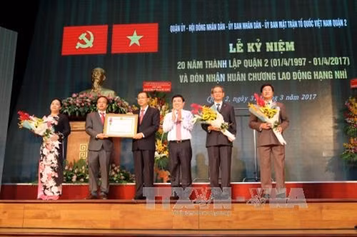 Chủ tịch UBND Thành phố Hồ Chí Minh Nguyễn Thành Phong thừa lệnh Chủ tịch nước trao Huân chương Lao động hạng Nhì cho Đảng bộ, Chính quyền và Nhân dân Quận 2. Ảnh: Thanh Vũ - TTXVN