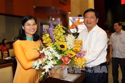 Bí thư Thành ủy Đinh La Thăng tặng hoa chúc mừng sinh nhật đồng chí Nguyễn Thị Thanh Thảo, Bí thư Đảng ủy Phường 2, quận Phú Nhuận. Ảnh: Thanh Vũ - TTXVN