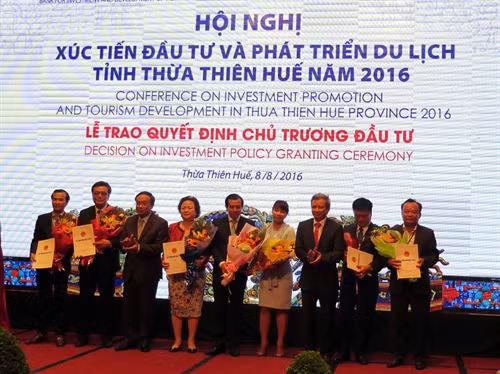 Lãnh đạo tỉnh Thừa Thiên - Huế trao quyết định cho 16 nhà đầu tư. Ảnh: Quốc Việt – TTXVN