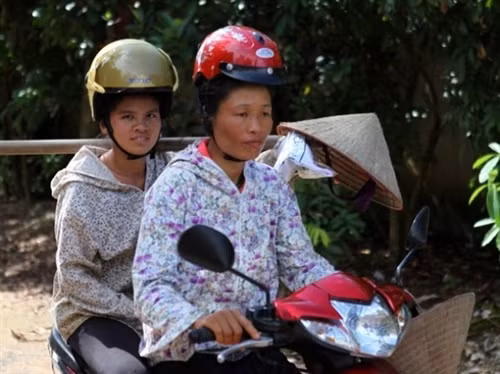Phụ nữ dân tộc vùng cao vẫn giữ truyền thống búi tóc cao và khi đội mũ bảo hiểm sẽ rất khó khăn. (Ảnh: CTV Xuân Phúc)