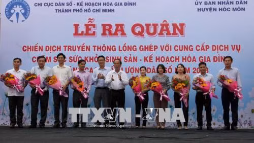 Ban tổ chức tặng hoa động viên 12 xã, thị trấn của huyện Hóc Môn ra quân Chiến dịch năm 2018. Ảnh: Tiến Lực – TTXVN