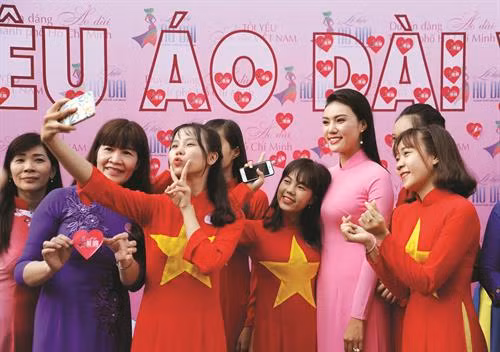 Các bạn trẻ, người dân Thành phố Hồ Chí Minh trong trang phục Áo dài chụp ảnh lưu niệm cùng với các đại sứ hình ảnh của Lễ hội. Ảnh: An Hiếu