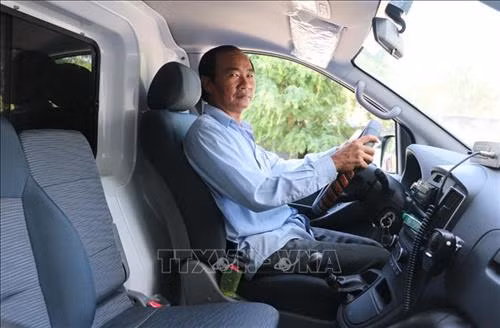 Ông Ngô Văn Đậu trực tiếp lái xe chuyển viện miễn phí giúp bà con nghèo. Ảnh: Công Mạo-TTXVN