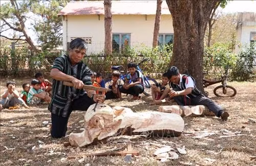Nghệ nhân ưu tú Ksor Krôh truyền dạy nghề cho lớp trẻ trong làng. Ảnh: Hồng Điệp - TTXVN