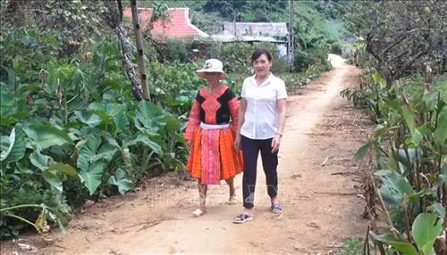Cô giáo Hà Thị Hằng đến các hộ gia đình vận động người dân đến lớp xóa mù chữ. Ảnh: Thanh Hải - TTXVN