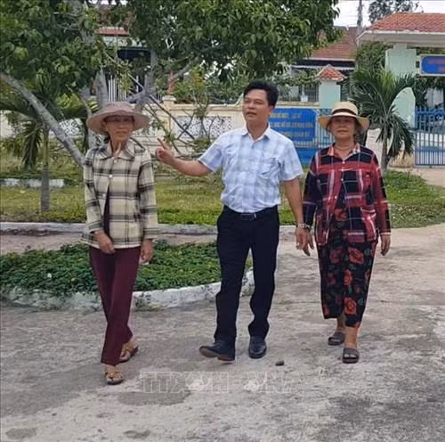 Bà Lê Thị Út (bên phải) và bà Lê Thị Bảy (bên trái) cùng lãnh đạo UBND xã Đức Bình Đông về thăm trường. Ảnh: Xuân Triệu - TTXVN