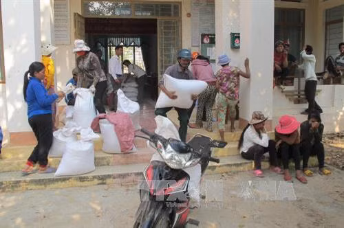 Hộ gia đình nghèo, có hoàn cảnh khó khăn thiếu đói trong thời gian giáp hạt được nhận gạo hỗ trợ của nhà nước. Ảnh: Hoài Nam – TTXVN