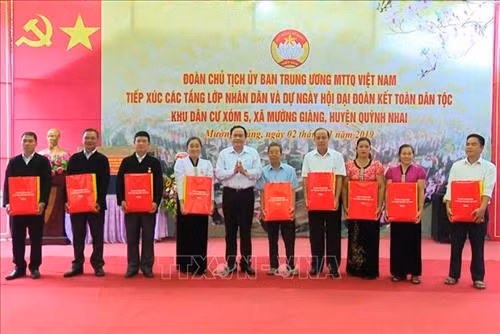 Chủ tịch Ủy ban Trung ương MTTQ Việt Nam Trần Thanh Mẫn tặng quà các hộ dân ở xã Mường Giàng, huyện Quỳnh Nhai, tỉnh Sơn La đã gương mẫu trong thực hiện di dân tái định cư. Ảnh: Nguyễn Cường - TTXVN