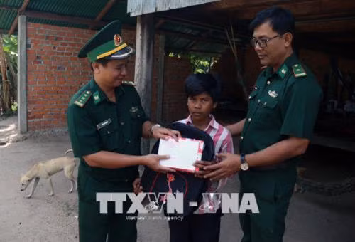 Cán bộ Đồn Biên phòng Phú Mỹ trao quà, tiền cho trẻ hoàn cảnh khó khăn tại ấp Tà Hưng, xã Pray Cơ Rớ, huyện Kampong Trach, (Vương quốc Campuchia). Ảnh: Lê Huy Hải – TTXVN