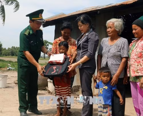 Cán bộ Đồn Biên phòng Phú Mỹ trao quà, tiền cho trẻ hoàn cảnh khó khăn tại ấp Tà Hưng, xã Pray Cơ Rớ, huyện Kampong Trach, (Vương quốc Campuchia). Ảnh: Lê Huy Hải – TTXVN