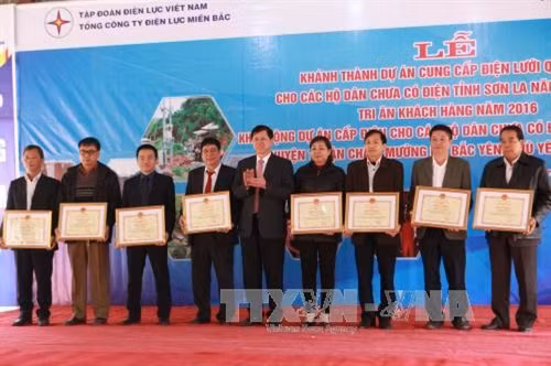 Chủ tịch UBND tỉnh Sơn La Cầm Ngọc Minh tặng bằng khen cho các tập thể, cá nhân có thành tích xuất sắc trong dự án. Ảnh: Lê Hữu Quyết - TTXVN